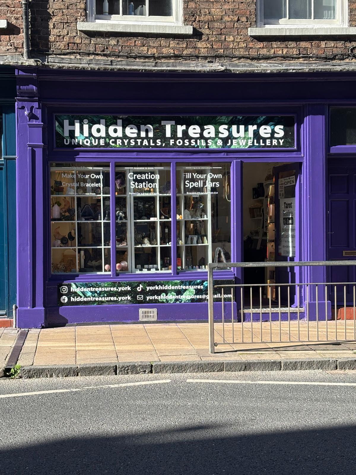 The purple Hidden Treasures York shopfront with Creation Station window signs