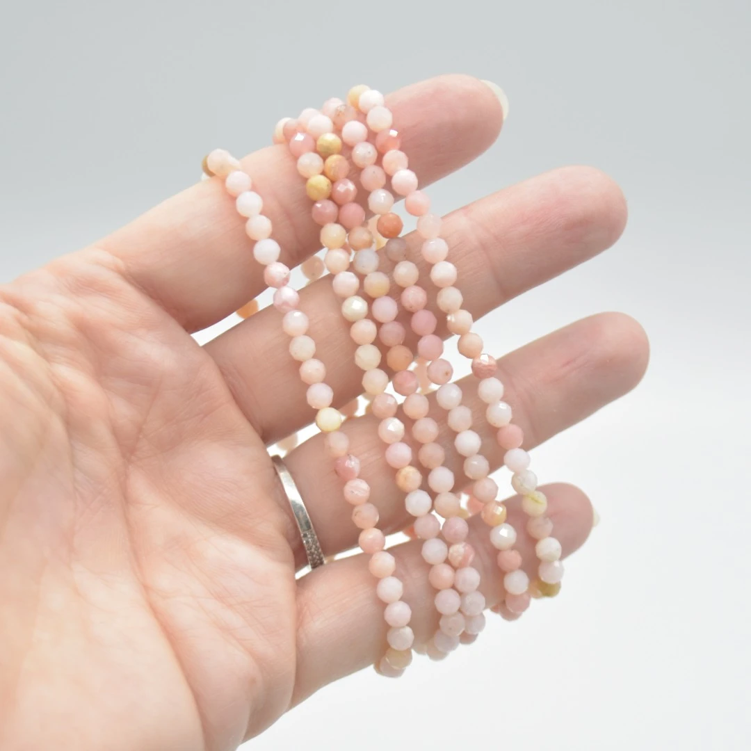 Hand holding pink beaded crystal bracelets